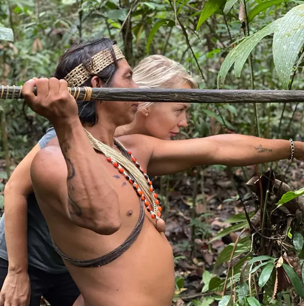 Hombre waorani enseñando a apuntar con la cerbatana