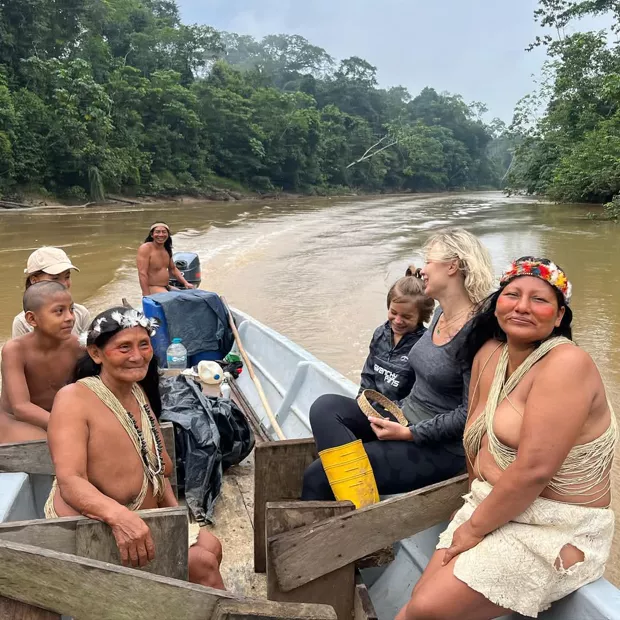 Familia waorani y viajeros compartiendo el bote de regreso