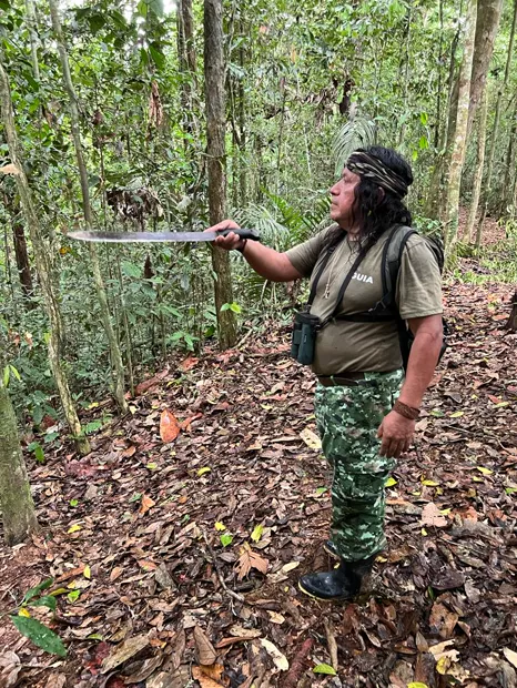 Guía waorani con un machete en un sendero del bosque