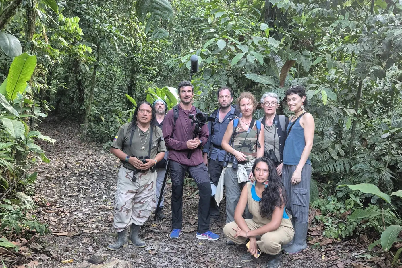 Grupo de visitantes con equipo fotográfico en un sendero de la selva